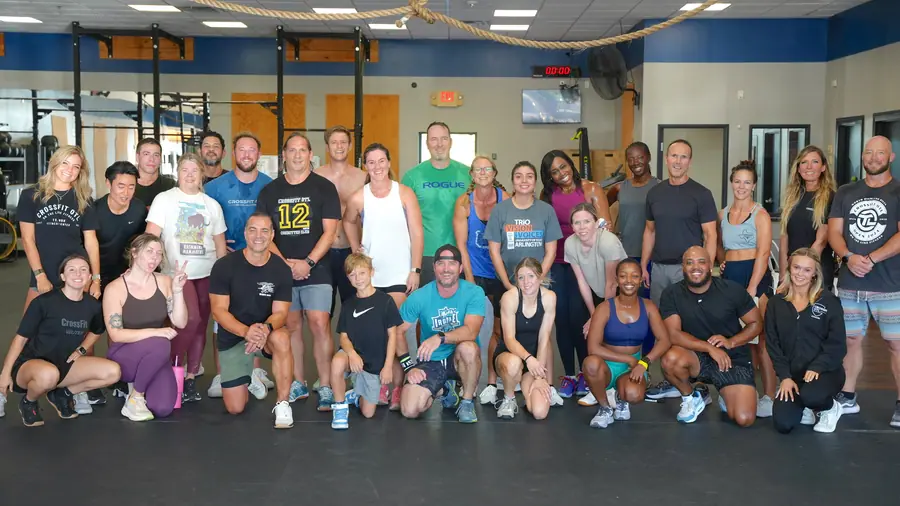 A big group of CrossFit OTL members smiling together on the gym floor